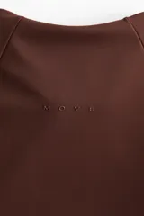 Top deportivo de manga larga en tejido funcional SculptMove, color marrón, con cuello elevado, medio cierre frontal y mangas raglán con abertura para el pulgar.