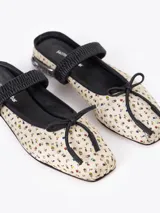 Ballerina tipo mule confeccionada en seda con estampado floral, ribetes en cuero negro, elástico en el empeine, lazo decorativo en la punta y taco bajo con incrustaciones de strass.