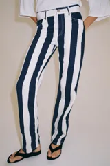 Jeans de tiro medio de corte slim, con diseño de rayas verticales a contraste en color azul marino y blanco. Cuenta con cinco bolsillos, trabillas para cinturón y cierre frontal con cremallera y botón metálico.