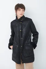 Chaquetón de efecto cuero en color marrón, con interior y detalles en corderito color bordó. Presenta cierre frontal con cremallera y botones a presión, cuello solapa y mangas largas con puños de corderito.
