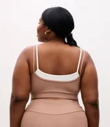 Top deportivo Get Over confeccionado en microfibra, de diseño con superposición en contraste de color blanco sobre tono tostado, con breteles finos dobles y sustentación leve.