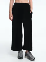 Pantalon de corte ancho y silueta recta, con cintura elástica y bolsillos laterales. Presenta una textura acanalada sutil.