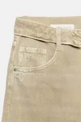 Jeans de tiro medio confeccionados en denim con diseño de cintura doblada y trabillas, cinco bolsillos, cierre frontal con cremallera y botón metálico, lavado claro y roturas en las rodillas.