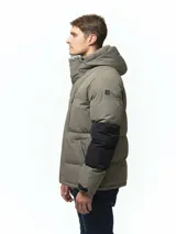 Campera puffer con capucha, de diseño bicolor en tonos gris topo y negro. Presenta cierre frontal con solapa de botones, bolsillos laterales y ajuste en los puños.