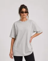 Remerón de corte oversize, color gris claro, con cuello redondo y mangas cortas de diseño holgado.