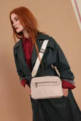 Bandolera de diseño moderno y funcional, confeccionada en nylon color marrón claro. Cuenta con múltiples compartimentos con cierre metálico, herrajes plateados y una correa ancha ajustable con detalle de marca.