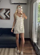 Vestido corto marrón con estampado de flores blancas, escote en V y tirantes finos.