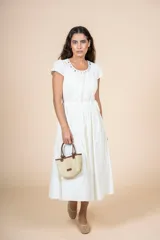 Vestido midi de color blanco con silueta recta, escote redondo adornado con apliques metálicos y mangas cortas. Incluye un lazo ajustable en la cintura para entallar la prenda.