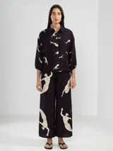 Pantalón palazzo negro con estampado de sirenas en color beige.