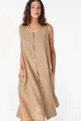 Vestido midi celeste de lino italiano, sin mangas, con escote redondo y cierre frontal abotonado con bolsillos laterales y corte holgado.