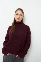 Polera de cuello alto confeccionada en tejido de punto, con manga larga y costura central decorativa en el frente.