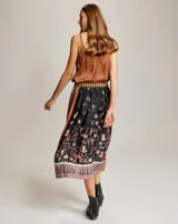 Top de tirantes finos con escote en V, confeccionado en viscosa con estampado temático western que incluye motivos de vaqueros, cactus y herraduras sobre fondo negro.