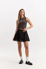 Minifalda negra de algodón con textura bordada y diseño de volados en capas.
