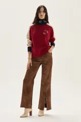 Sweater de tejido de punto con mangas raglan, cuerpo principal rojo, mangas color beige y puños y cuello en azul marino. Presenta un bordado central con un motivo de pájaro y espigas.