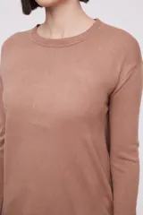 Sweater negro de tejido liso, manga larga y cuello redondo a la base. Presenta un calce holgado.