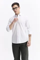 Camisa clásica lisa de manga larga color negro, con cartera abotonada, logo bordado en el pecho y fit slim.