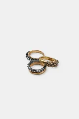 Pack de tres anillos metálicos con acabados en dorado y plateado, decorados con incrustaciones de cristales brillantes y texturas irregulares.