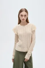 Sweater de algodón color natural, de punto con diseño calado, cuello redondo a la base y mangas largas con volados en los hombros.