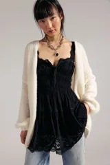 Mini vestido slip negro de tela liviana y fruncida, con escote corazón, cierre delantero regulable de gancho, tiras regulables y encaje translúcido en los bordes y el ruedo. Silueta entallada en la parte superior y con vuelo en la falda.