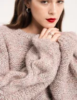 Buzo tejido a mano con lana, color rosa con motas de colores. Diseño oversized, largo entre la cintura y la cadera, con detalle de trenzas en las mangas.