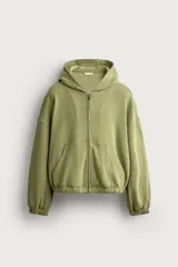 Cazadora relaxed fit de hombre, confeccionada en tejido estructurado tipo waffle con efecto lavado en color verde. Cuenta con cuello con capucha, cierre frontal con cremallera, bolsillos frontales tipo canguro y acabados elásticos en puños y bajo.