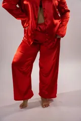 Pijama de seda rojo, compuesto por una camisa de manga larga con cuello solapa y botones frontales, y un pantalón largo a juego.