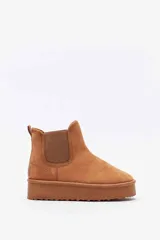 Bota corta de gamuza color tostado, tipo botineta, con paneles elásticos laterales y suela de plataforma plana.