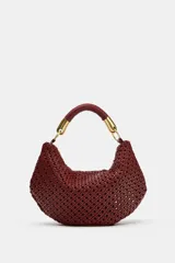 Bolso de hombro bordó con diseño trenzado y forma curva tipo hobo. Cuenta con un asa corta estructurada con detalles metálicos dorados en los extremos.
