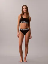 Corpiño deportivo Calvin Klein de microfibra, con diseño de doble capa frontal, cuello abierto y banda elástica con el logo de la marca en contraste.