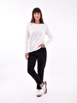 Remera negra de manga larga con cuello redondo y detalle de tachas doradas dispuestas en diagonal sobre el pecho.