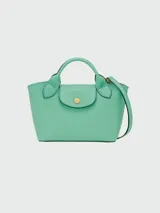 Cartera tipo shopper tamaño XS de la línea Épure de Longchamp, confeccionada en cuero de color verde menta. Presenta una estructura rígida, asas cortas superiores y un cierre de solapa con botón a presión metálico dorado.