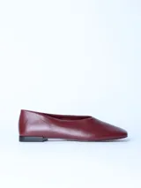 Zapato tipo ballerina de cuero color bordó, con punta cuadrada y suela plana.