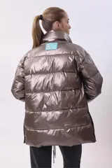 Campera puffer color bronce, con cuello alto, cierre frontal y bolsillos laterales con cierre.