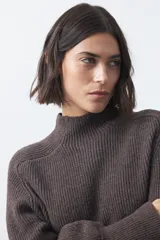 Polera de tejido de punto en color marrón oscuro, con cuello alto y diseño de silueta relajada.