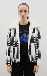 Campera con estampado de bosque en tonos azules, cuello de sherpa en color crema y cierre frontal con cremallera. Cuenta con elástico ajustable en la cintura.