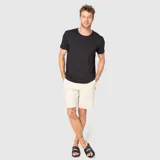 Short de corte clásico color beige, con cierre frontal de botón y cremallera, bolsillos laterales y tejido técnico de secado rápido.