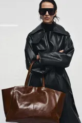 Bolso tipo shopper confeccionado en piel, con diseño de doble asa de hombro y cierre mediante botón imantado. Incluye bolsillo interior.