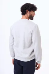 Buzo de felpa color negro, con cuello redondo, mangas largas y puños elásticos. Diseño básico y minimalista.