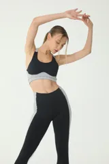 Calza deportiva negra con recortes laterales en gris, cintura alta con recorte en V y logo BASSET 00's en blanco.