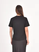 Remera negra de algodón con cuello redondo y mangas cortas, presenta la frase 'Don't text me' estampada en el centro del pecho con tipografía cursiva blanca.