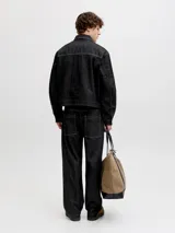 Chaqueta de denim negro con costuras en contraste color blanco, bolsillos frontales con solapa y cierre de botones metálicos.
