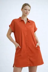 Camisa de corte holgado confeccionada en viscosa suave y liviana, con cuello clásico, cierre frontal de botones y mangas cortas con dobladillo. Cuenta con bolsillos laterales prácticos.