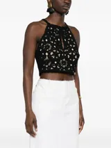 Top corto negro tejido a crochet con estampado floral, bordes festoneados y abertura en forma de lágrima.