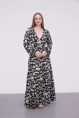 Vestido largo de poliéster con estampado floral en blanco y negro, escote en V, corte imperio con punto smock en la cintura y mangas largas con puños elásticos.