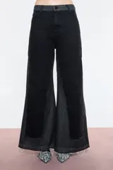 Pantalón de jean negro con corte wide leg y tiro alto. Diseño con dos tipos de denim, uno negro y otro gris, con recortes que resaltan la variación de telas.
