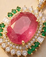 Collar de acero dorado con cadena fina y dije rectangular con gran piedra ovalada fucsia al centro, rodeada por pequeños cristales blancos y verdes.