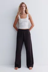 Jogger de felpa color marrón oscuro, con cintura elástica y cordón ajustable. Diseño de corte holgado con bolsillos laterales discretos y piernas amplias.