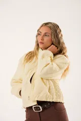 Campera color manteca con diseño acolchado de flores, cuello alto, cierre frontal con cremallera y bolsillos laterales.