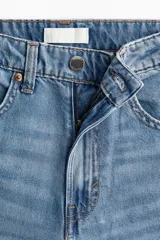 Jean wide leg de tiro alto en denim rígido de lavado claro, con diseño de cinco bolsillos y perneras amplias y holgadas.