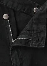 Pantalón de jean estilo wide leg con cintura cruzada y cierre frontal asimétrico. Cuenta con cinco bolsillos y trabillas para cinturón.